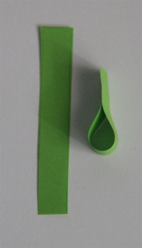 Pomysł na kartkę świąteczną Potrzebne materiały: - granatowy papier (gruby) – podstawa naszej kartki - papier biały - papier zielony  Do wykonanie choinki widocznej na zdjęciu potrzeba 16 pasków zielonego papieru. Jeden pasek powinien mieć szerokość 1 cm i długość 6 cm. Paski trzeba tak skleić, aby powstały z nich łezki (zdjęcie poniżej). Wyklejanie choinki zaczynamy od najniższej warstwy, czyli tej najszerszej. 